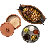Fajitas voor twee van boven: gietijzeren pan met ossenhaas, kip en paprika, tortilla's en schaaltjes guacamole, zure room, salsa, bonen en rijst