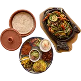 Fajitas veggie van boven: courgette, paprika, champignons en boontjes in de gietijzeren pan, met tortilla's en schaaltjes garnituur