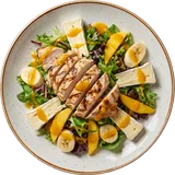 Salade Merimé van boven: gegrilde kip, brie, banaan en mango op gemengde sla