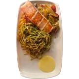 Zalmfilet van boven op pestopasta met warme groentjes op een wit bord
